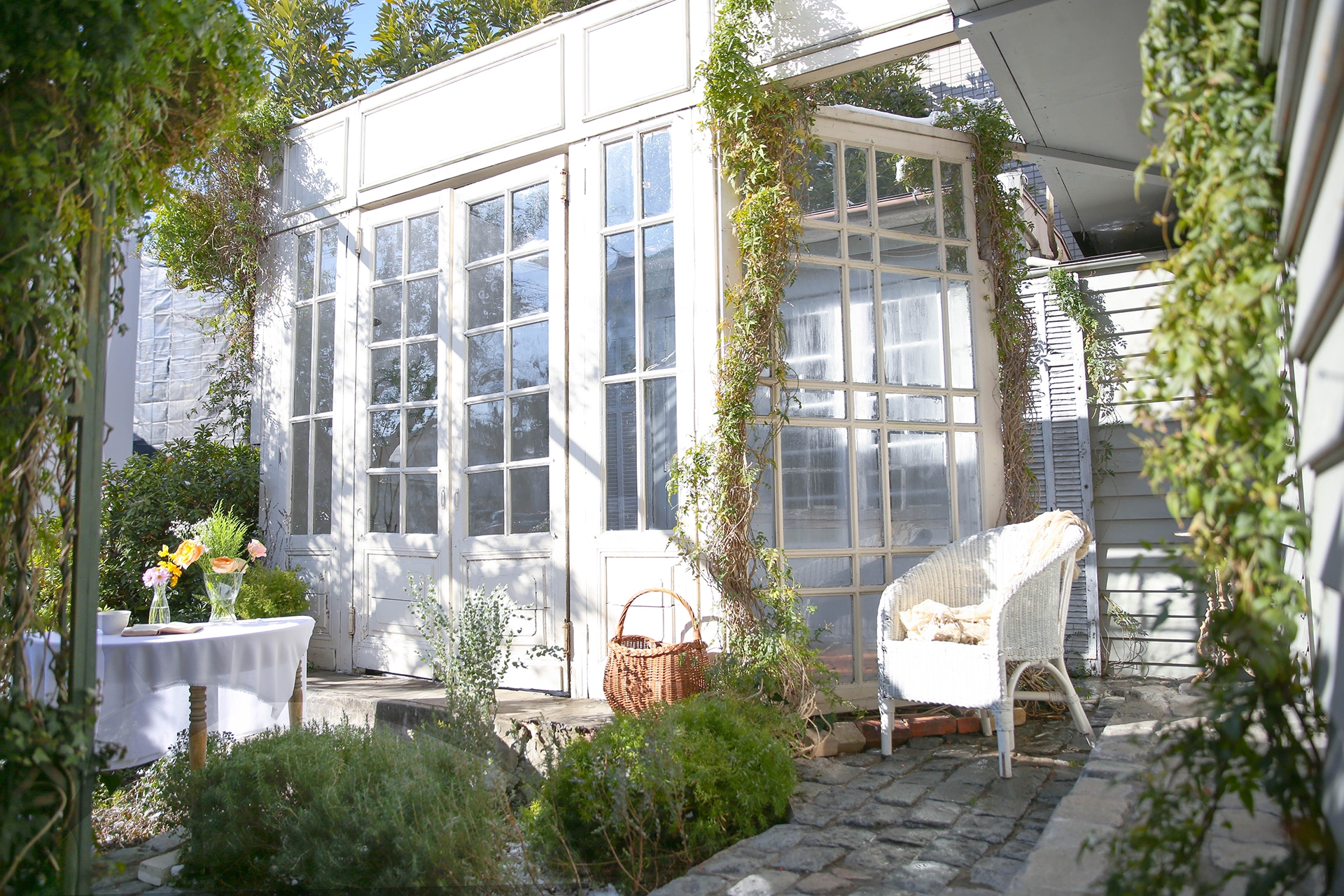 外観に建つ大きな白い扉とグリーン