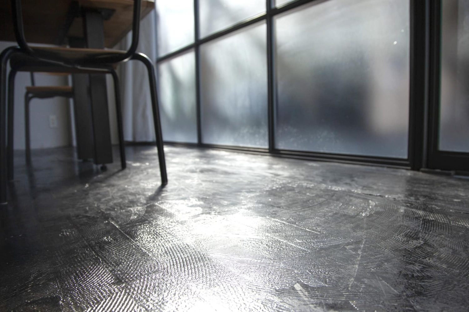 黒く塗装したモルタル床の質感
