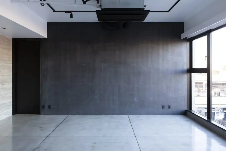 手塗りの粗い表情を残した黒の左官壁