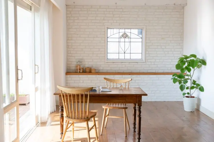 白いブリック壁とアクセントとなる窓を背景に