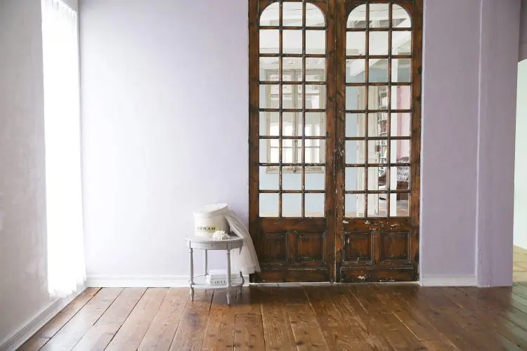 ダークブラウンの扉とくすみパープル壁