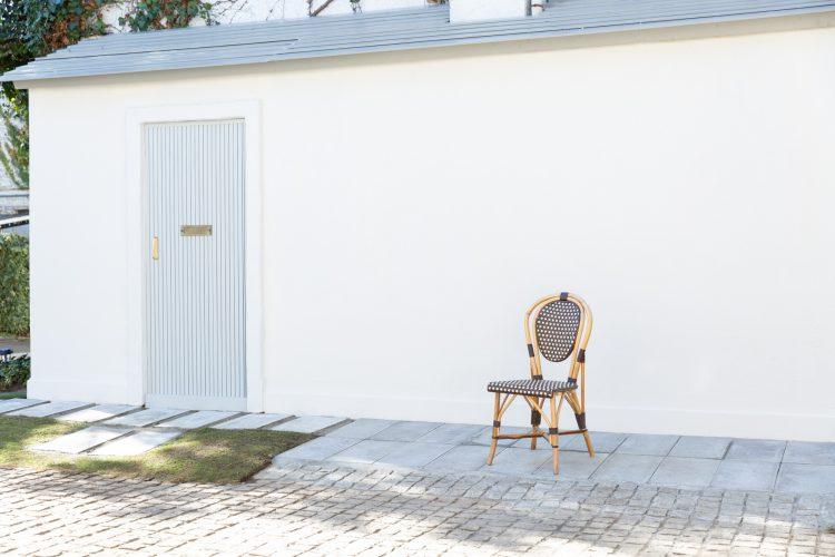 建物の向かいの白壁と淡い色の扉