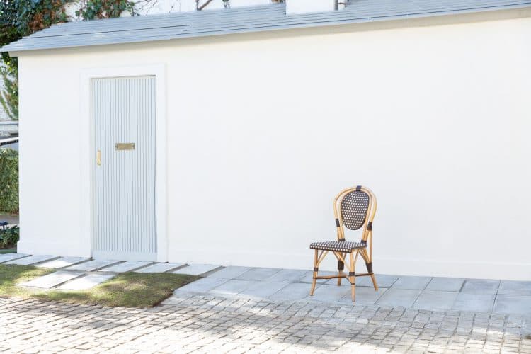 建物の向かいの白壁と淡い色の扉