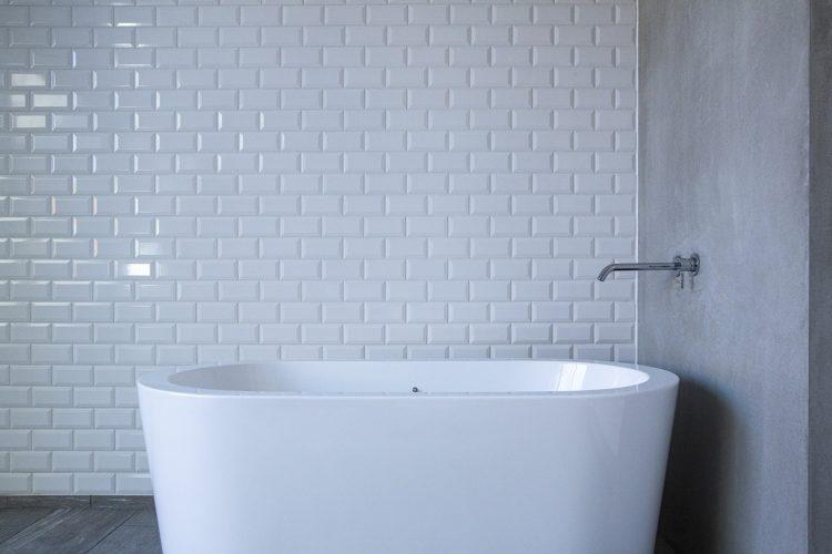 移動可能なバスタブと白タイル背景