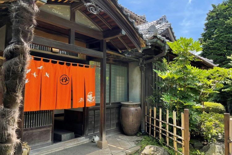 オレンジ色の暖簾が象徴的な離れの玄関