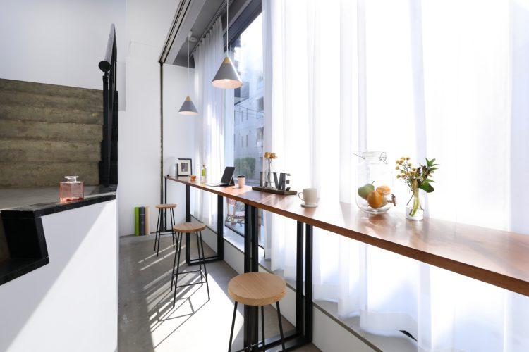 光が差し込む大きな窓とカフェカウンター