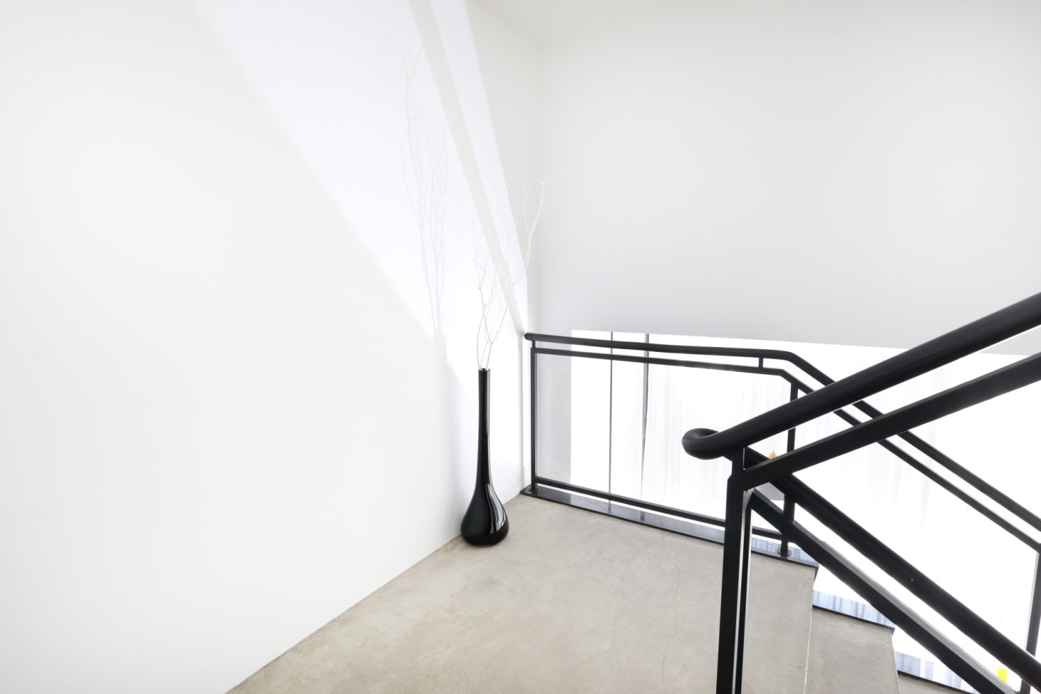 吹き抜け階段の踊り場はシンプルな白壁