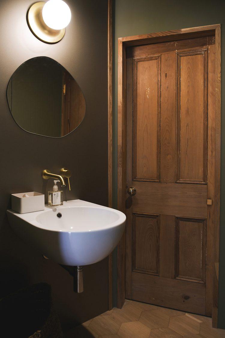 アンティークのドアと緑の壁の洗面