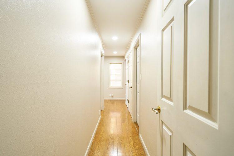 1st 1F / 複数の扉が並ぶ廊下 玄関側に向かって