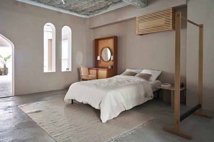 モルタル床とベージュ壁のベッドスペース