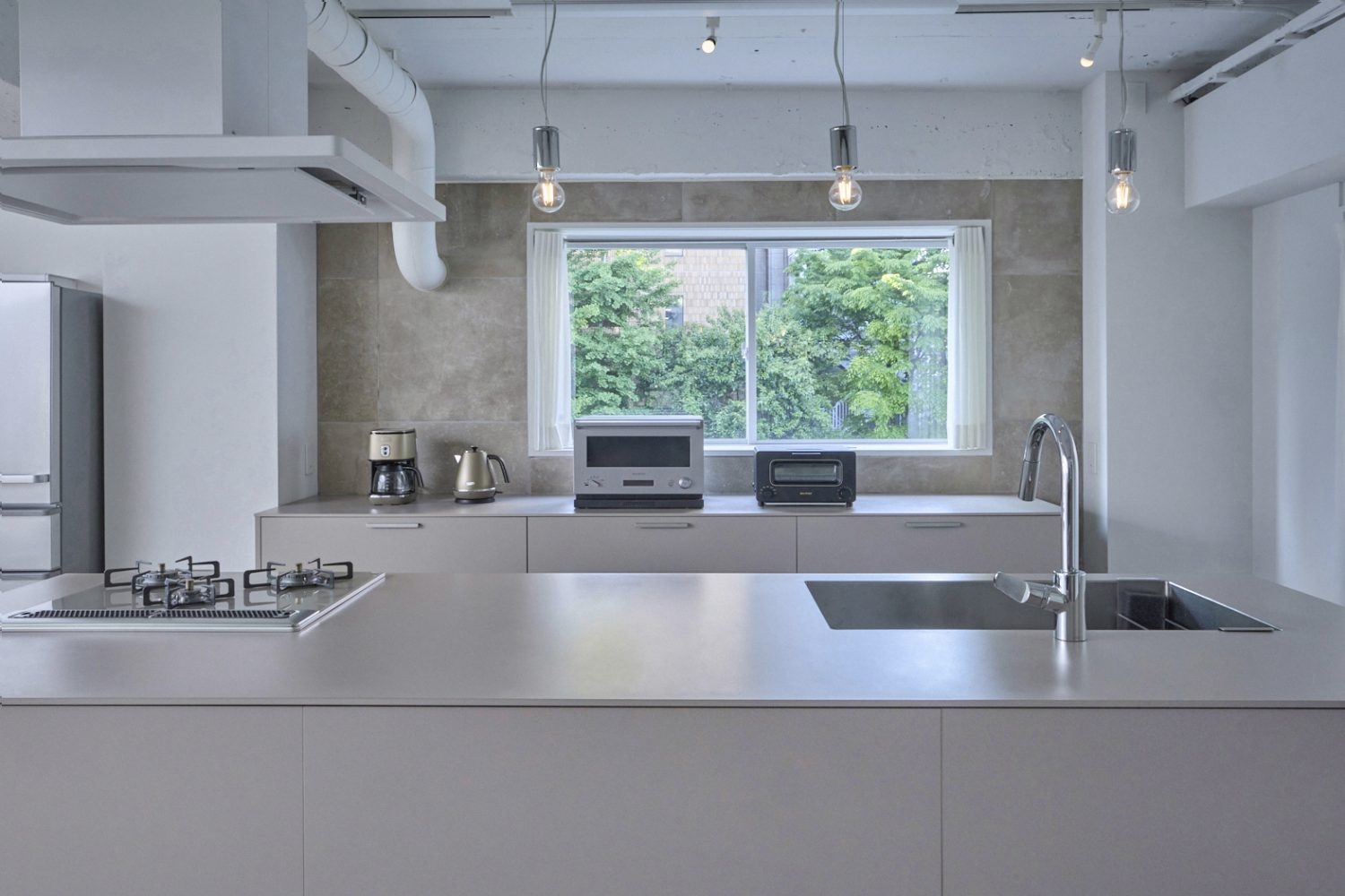 被写体と調和するカラーのキッチンと石目調の背景壁