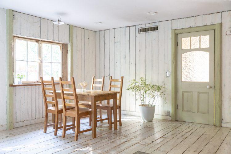 淡いグリーンの扉と白い板壁