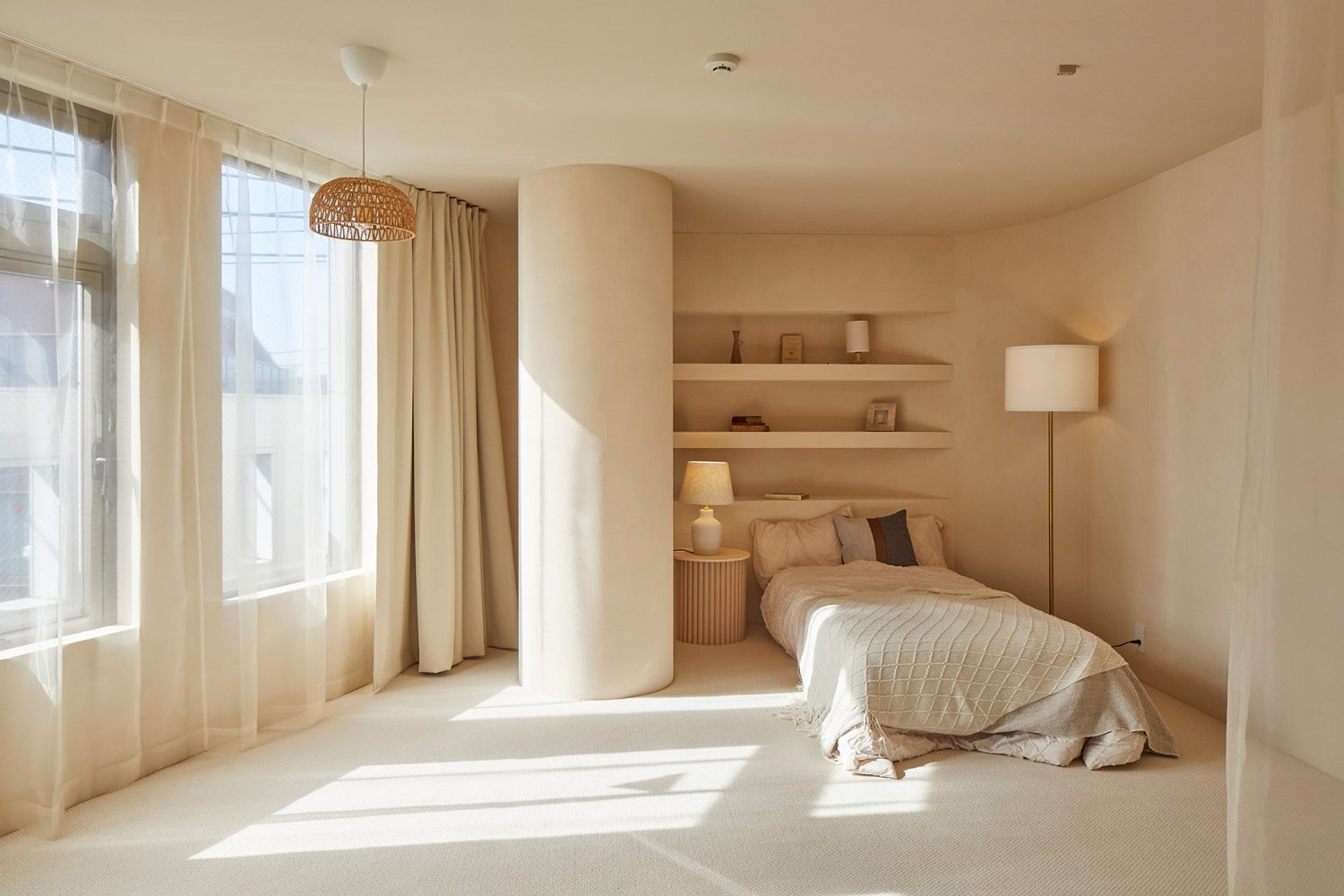 アール壁と円柱と掘り込み棚のあるベッドルーム