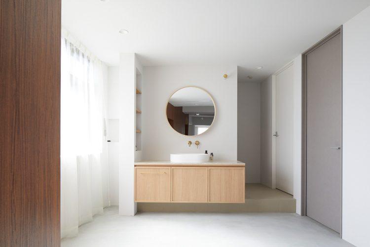 明るい南窓と棚のある大理石を使った洗面台