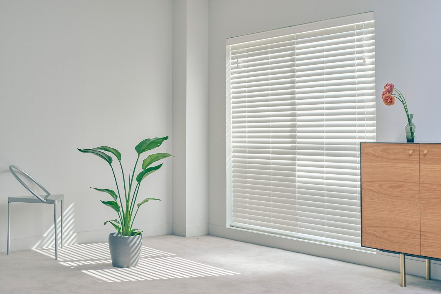 南向きの窓からブラインド越しに差し込む光