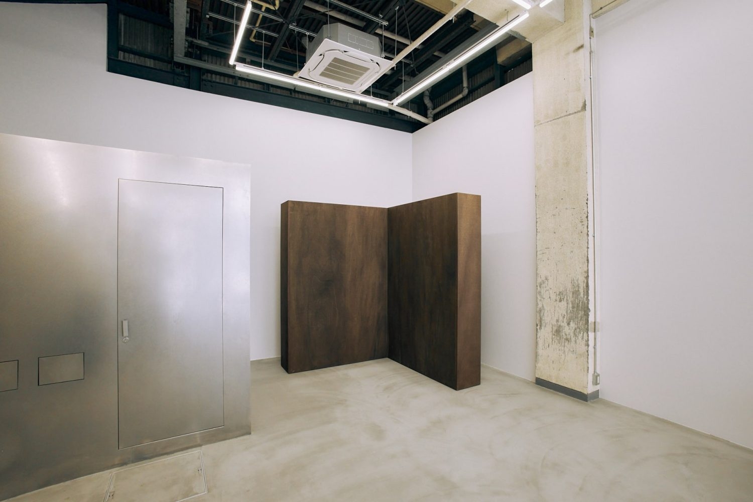 箱のようなシルバーのトイレと可動壁