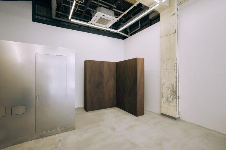 箱のようなシルバーのトイレと可動壁