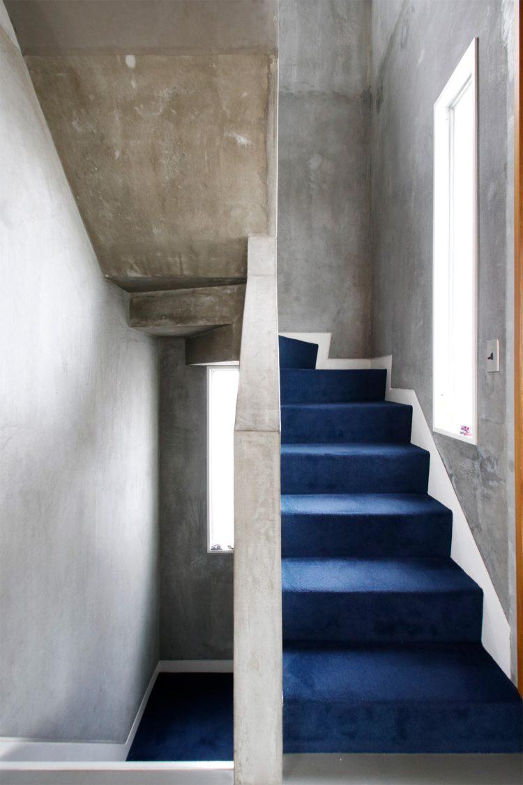 カーペットが敷き詰められた階段には小窓から光が