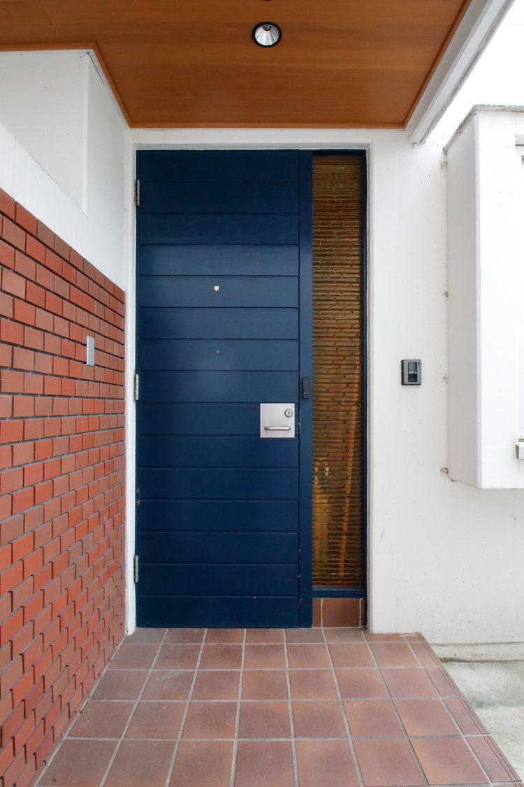 玄関はレンガ壁とブルーのドア