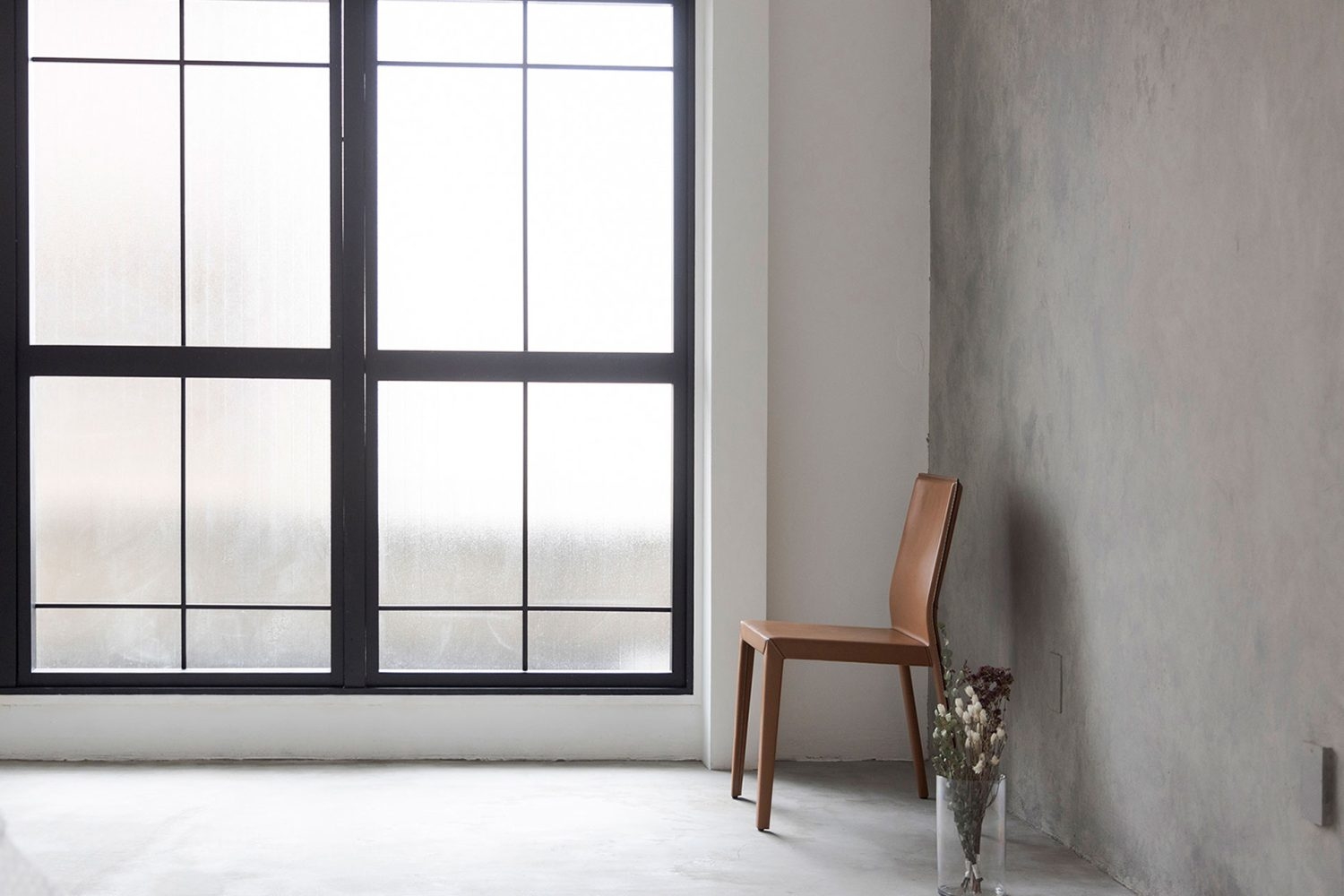 北側 / 黒の窓枠にモルタル風壁のソリッドな空間