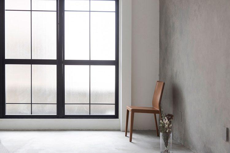 北側 / 黒の窓枠にモルタル風壁のソリッドな空間