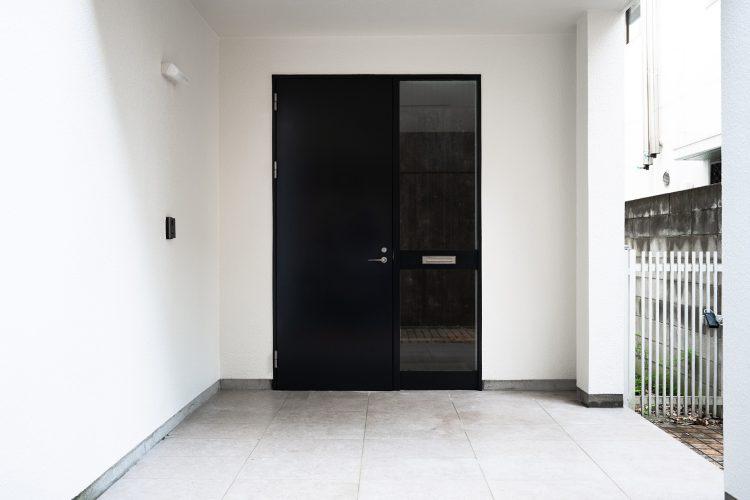 シンプルで大きな玄関扉と広いポーチ