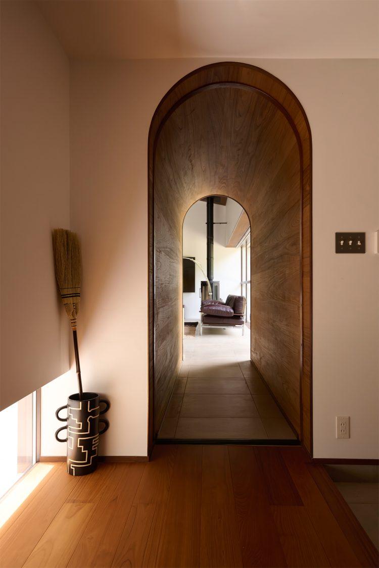 玄関からリビングに続くアーチ開口のアプローチ