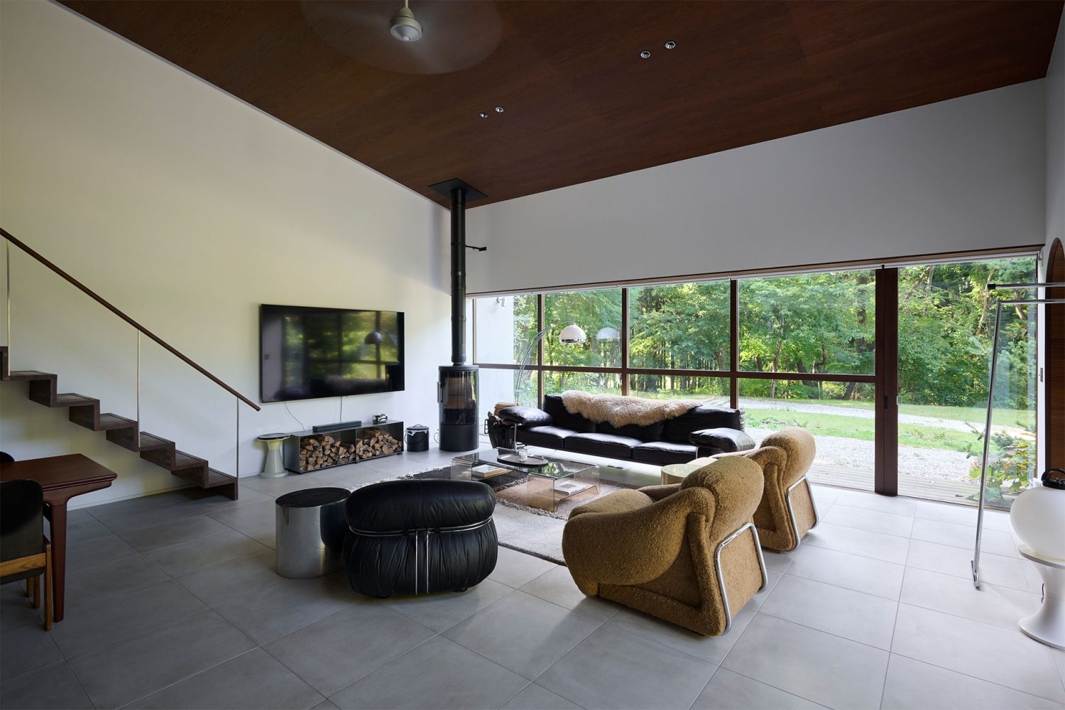 緑抜けの大きな窓から自然光が差し込むモダンな空間