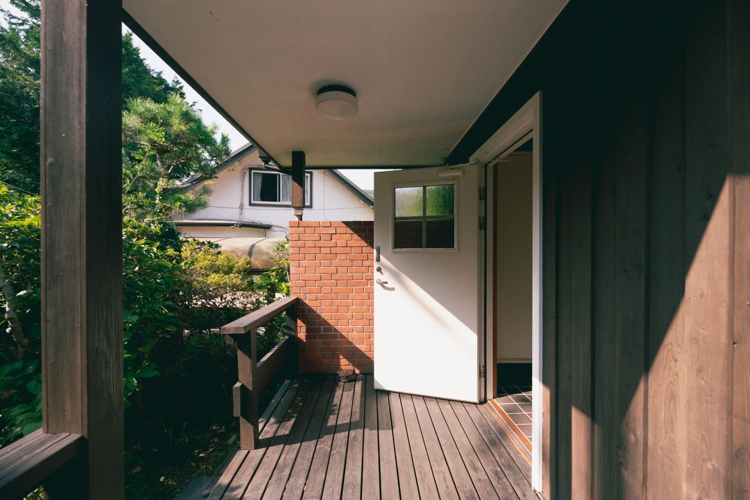 レンガ壁と白いドアの組み合わせが魅力的な玄関ポーチ