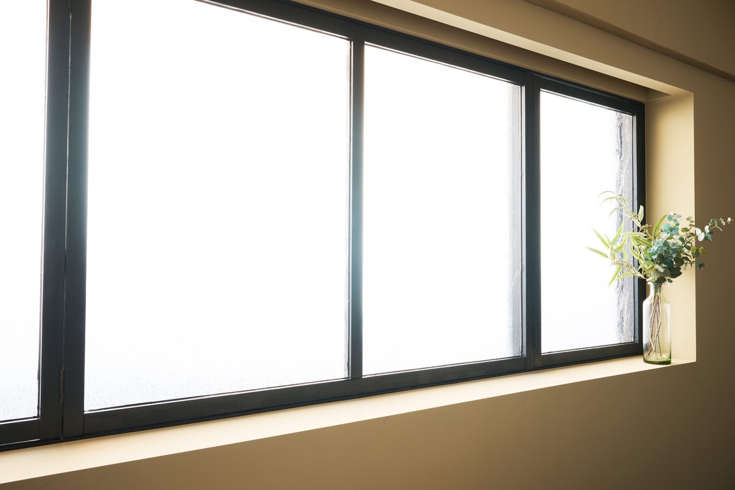 ベージュ壁に映えるブラックの窓枠