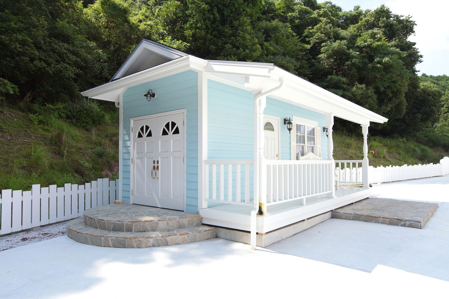 水色の壁と白い柱の可愛らしい小さな建物