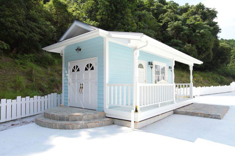 水色の壁と白い柱の可愛らしい小さな建物
