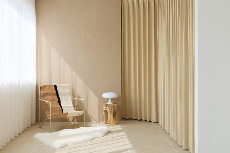 ベージュの左官壁と2色のカーテンに包まれる