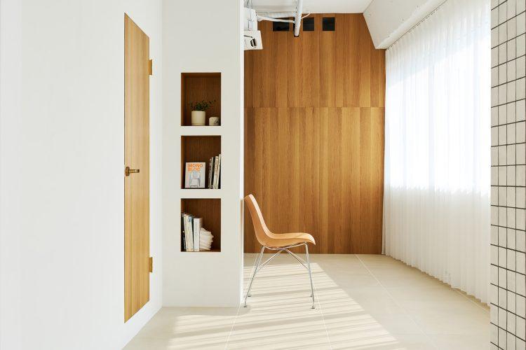 白壁に映えるウッドのドアとニッチ棚