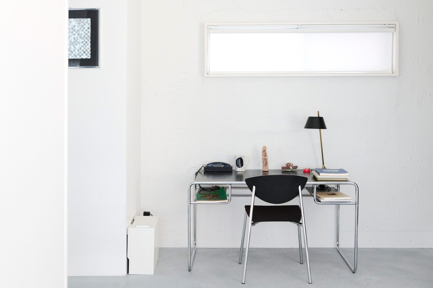 白壁に向かって配置された無機質なデスク