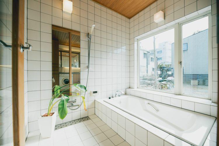 自然光が入る白タイルのバスルーム(お湯は出ません)