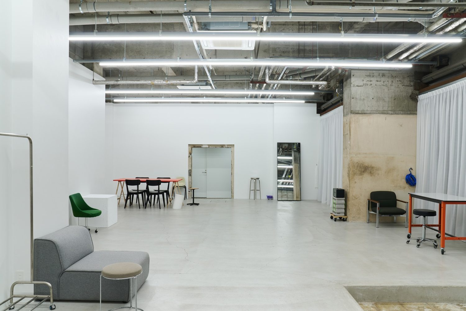 白壁とモルタル床のシンプルな天高空間