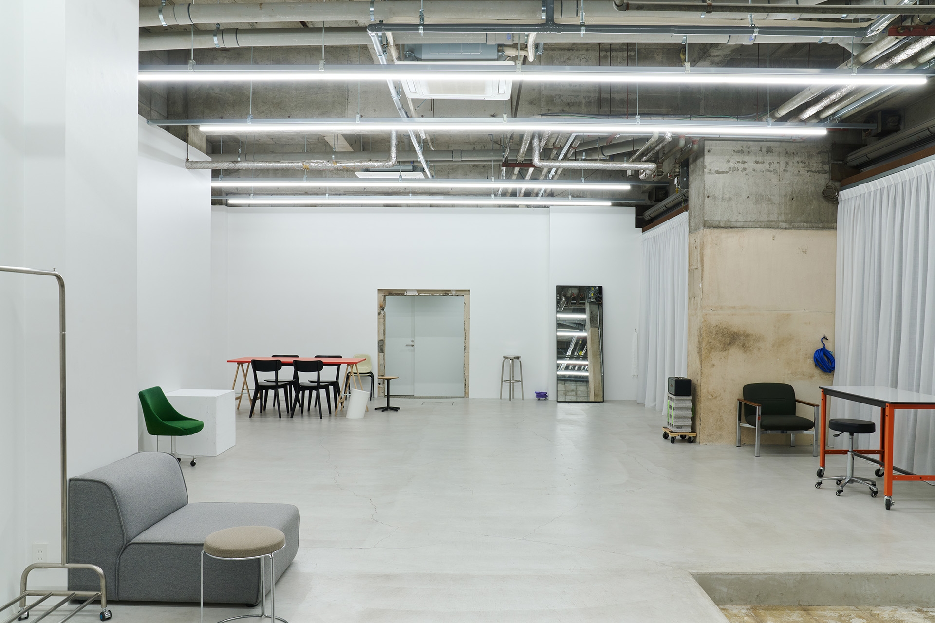 白壁とモルタル床のシンプルな天高空間