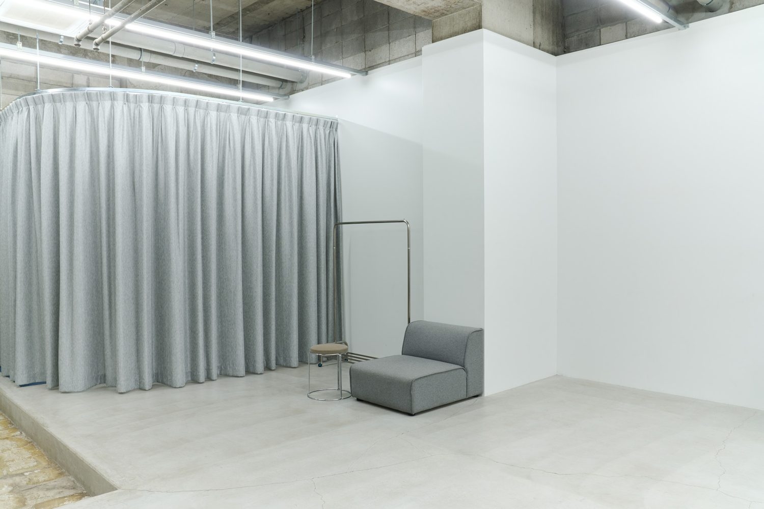 グレーのカーテン内はメイク・フィッティングスペース