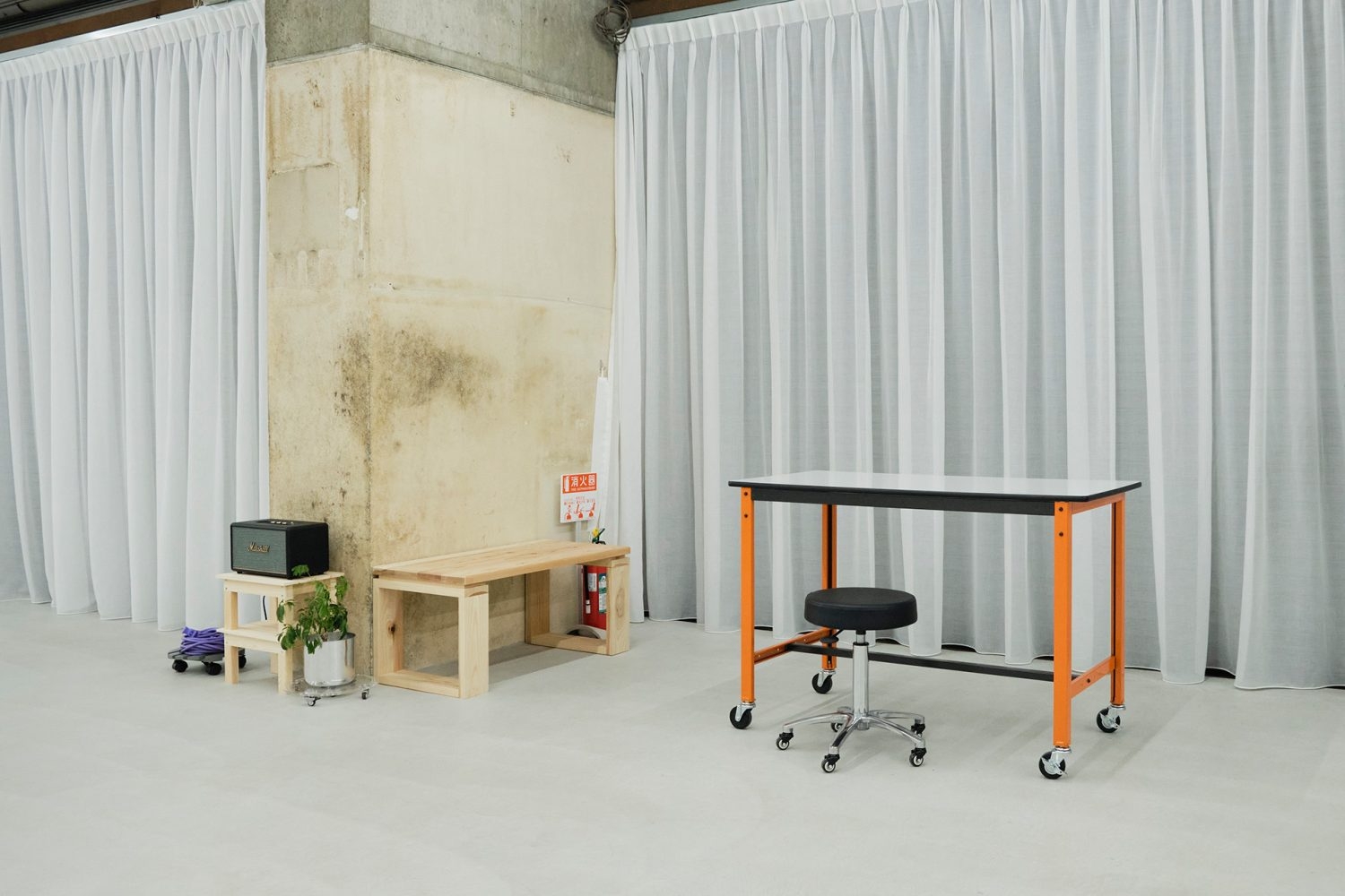 味のあるコンクリートの躯体・柱を背景に