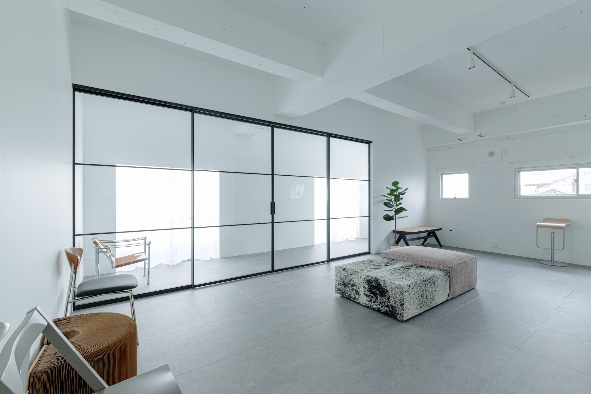 白壁とモルタル調のタイル床で構成された撮影スタジオ