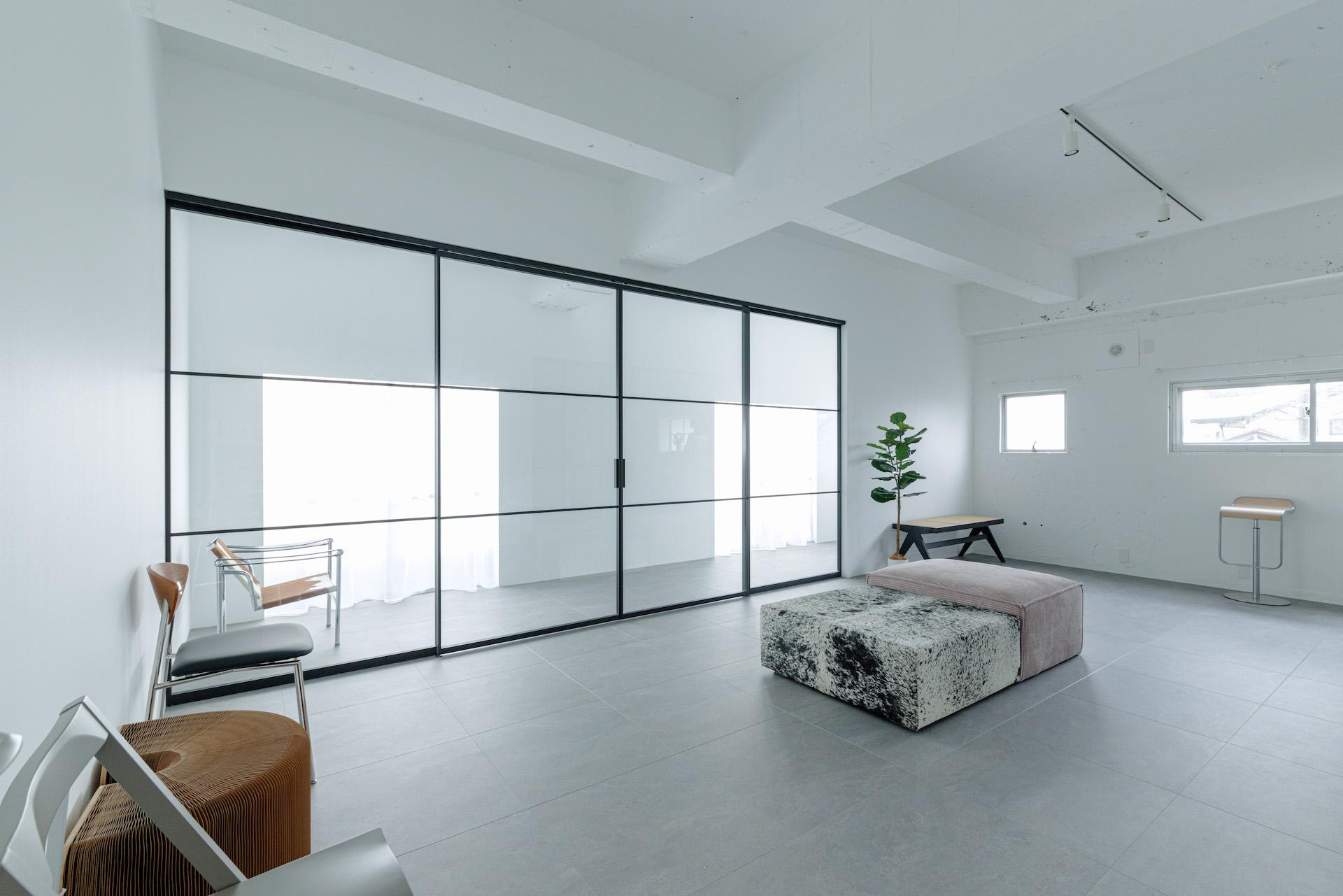 白壁とモルタル調のタイル床で構成された撮影スタジオ