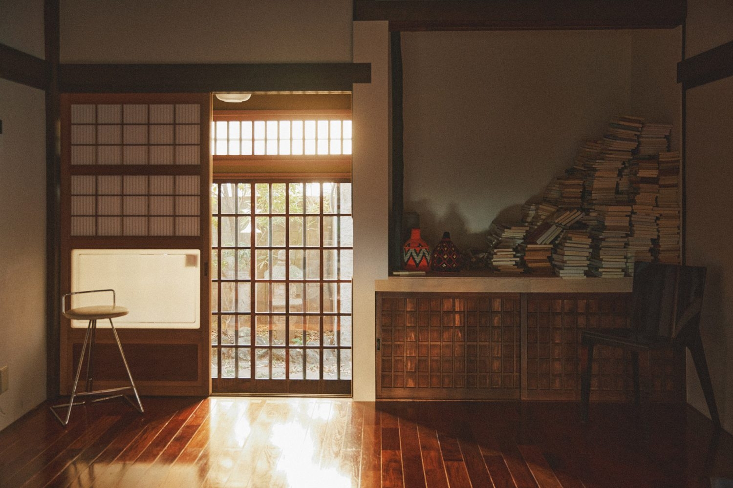 西陽が差し込む裏側入口 積み上げられた書籍