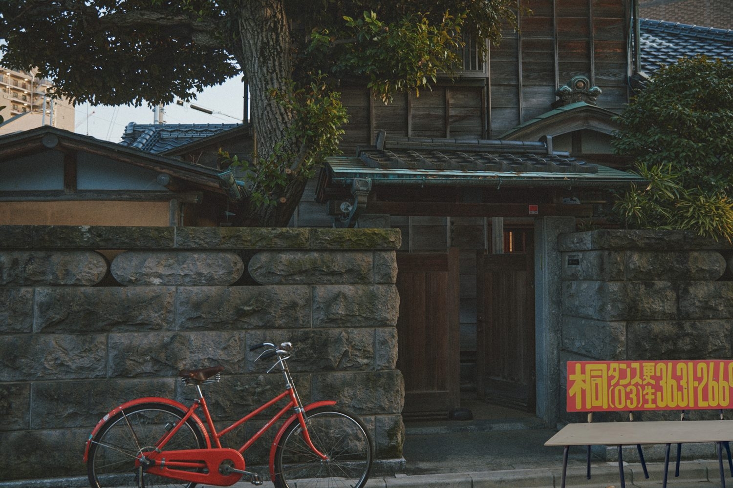 裏口門扉と石垣 レトロな自転車とベンチ