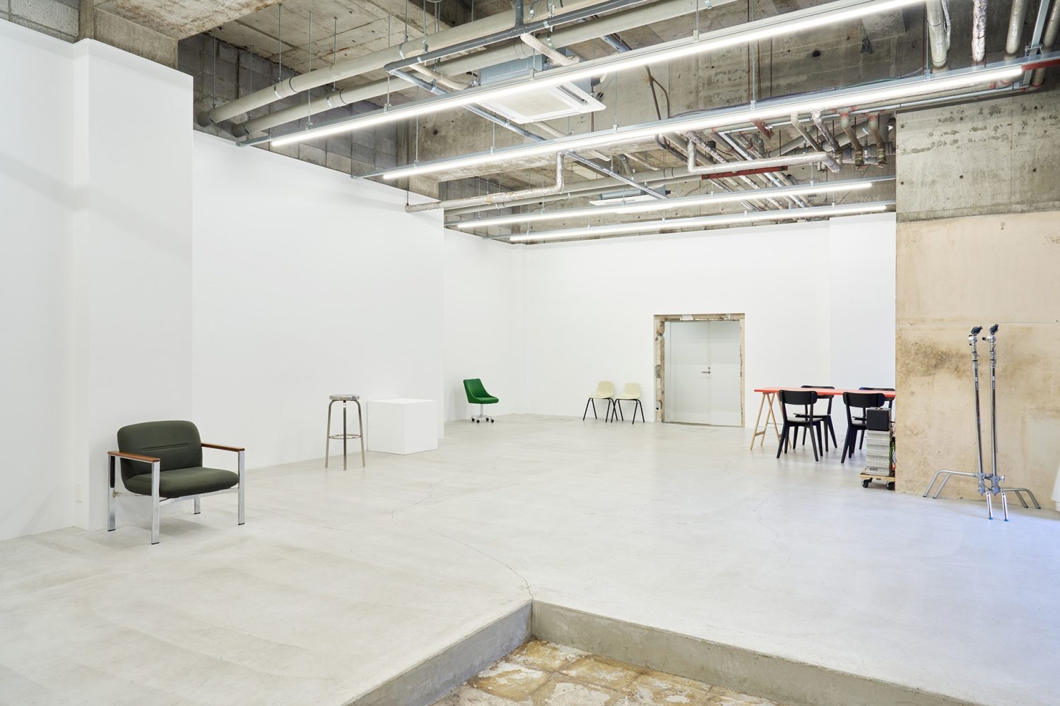 白壁とモルタル床のシンプルな天高空間