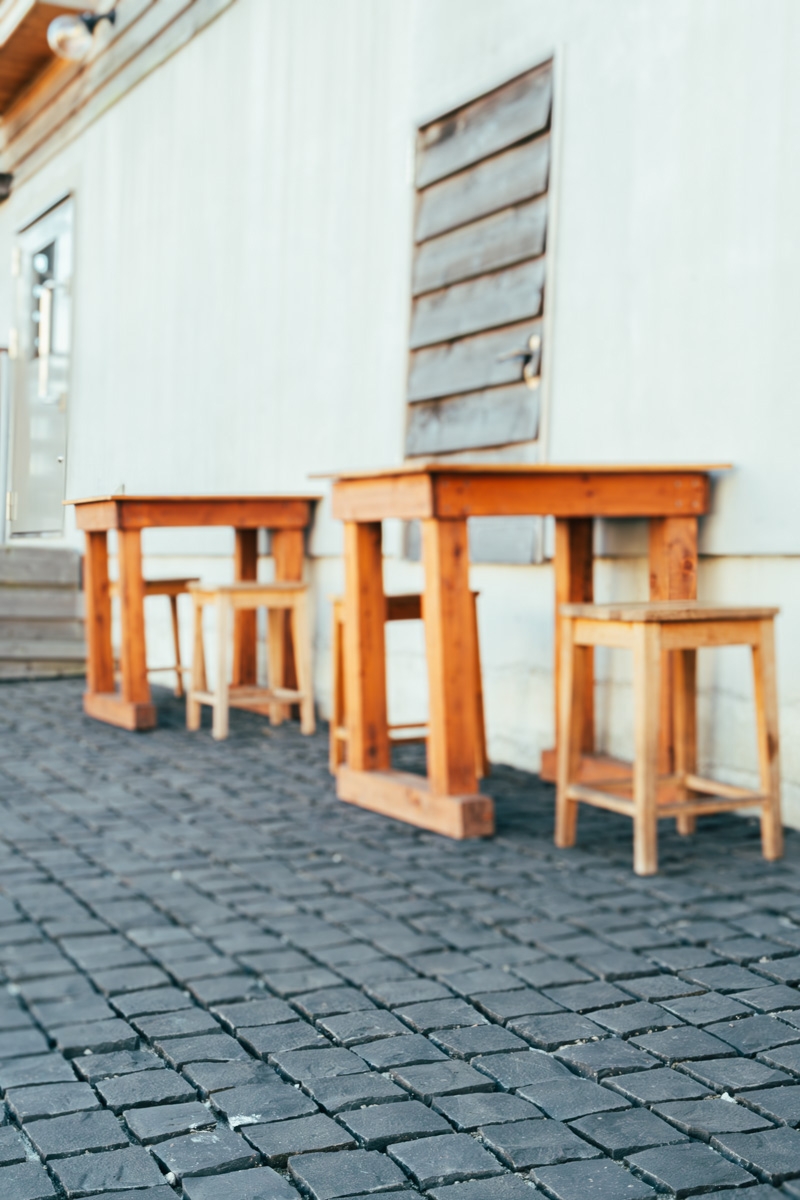 木製のテーブルと椅子が並ぶテラス席