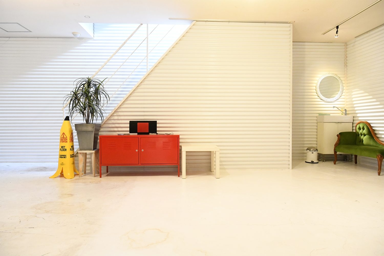 2F ペーパー撮影スペース左側の壁面 / 屋上に続く階段