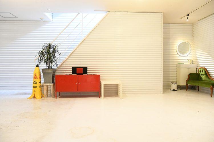 2F ペーパー撮影スペース左側の壁面 / 屋上に続く階段