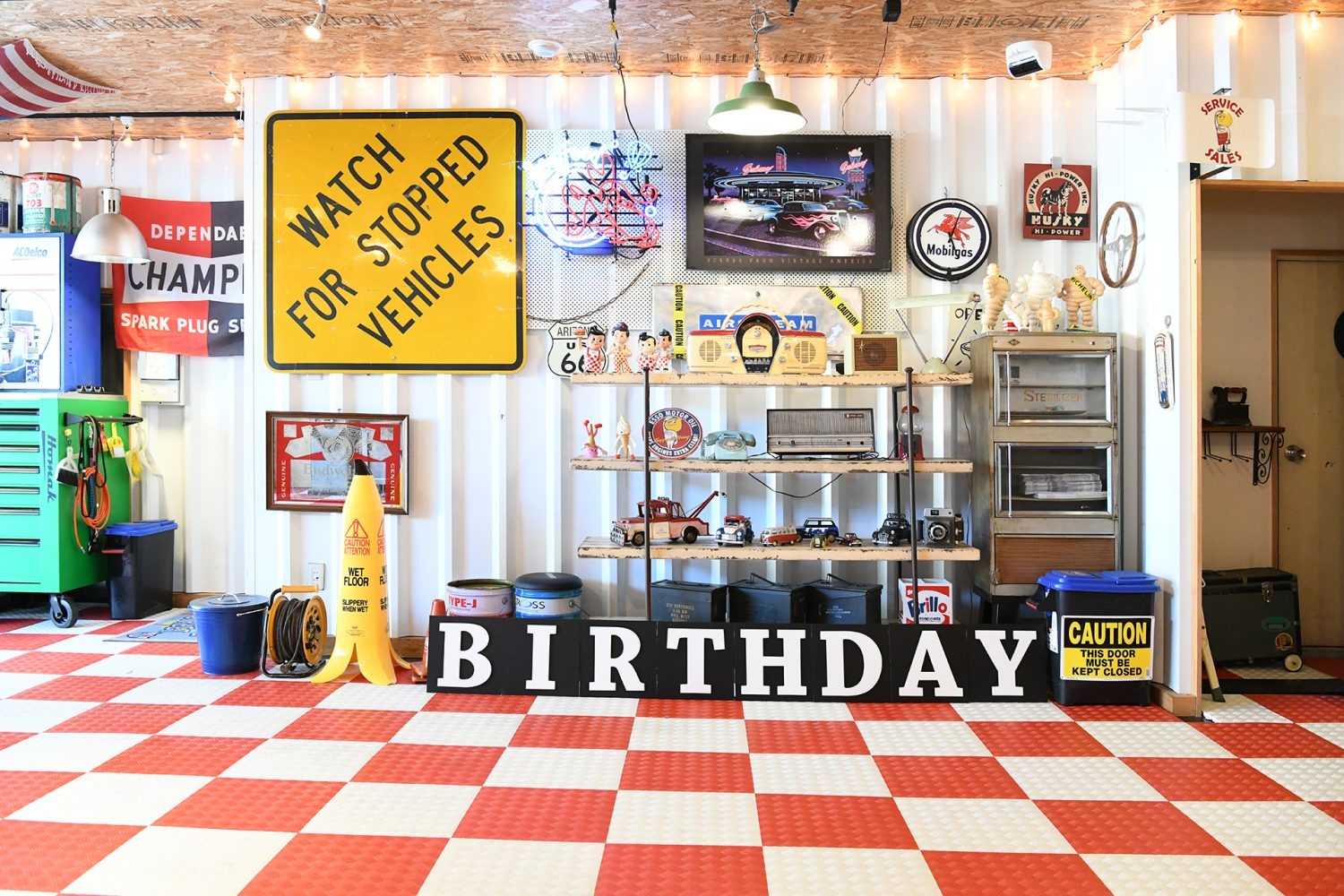 アメリカン雑貨やおもちゃが多数配置された棚を背景に