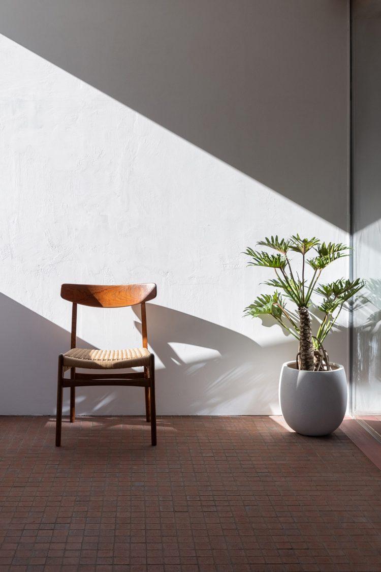 直射が差し込む無釉タイル床と漆喰壁のバルコニー